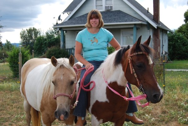 A girl on a horse with another horse beside them.